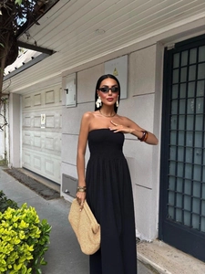 Detail of black strapless maxi dress with smocked bodice and elegant flowing skirt