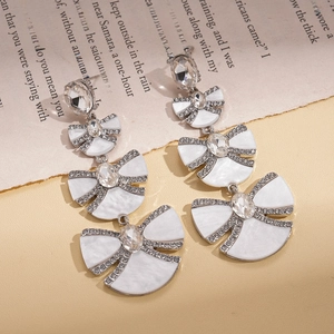 Elegant tiered bow fan earrings with silver plating and crystals on vintage book page