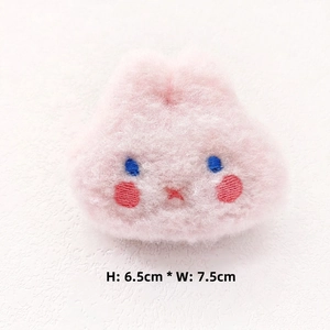 Detailed view of pink plush rabbit accessory with embroidery, size 6.5cm by 7.5cm
