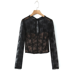 Close-up of black lace top with corset boning, sheer sleeves, and nude inner lining