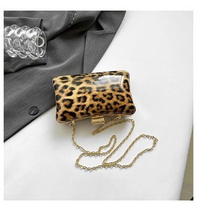 Flat lay of leopard print clutch bag with gold chain strap on white background