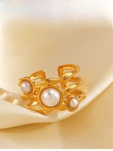 Detail of multi-layer gold plated ring with three white pearls on silk background