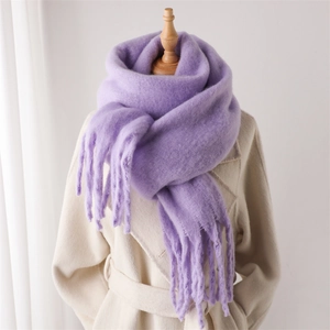 Détail d'une écharpe en mohair violette à franges sur un mannequin avec un manteau