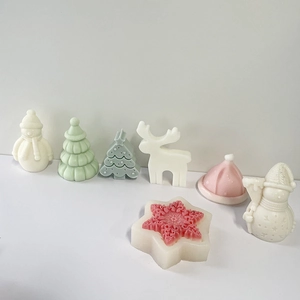 Detail showing colorful Christmas tree, snowman, and reindeer shaped candles in soft pastel hues