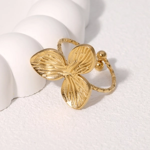 Detailed close-up of golden leaf ring with brushed texture and hammered finish band