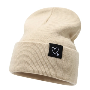 Bonnet en maille côtelée beige avec écusson cœur noir pour la chaleur hivernale