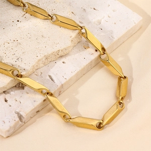 Detailed close-up of 18k gold plated stainless steel melon seed chain necklace on stone