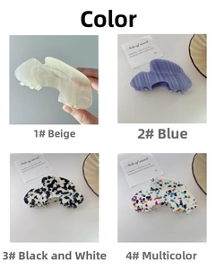 Macro view of four elegant acetate hair claws in beige, blue, marble, and colorful patterns