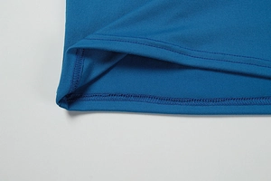 Nahaufnahme der feinen Nähte und des blauen Stricksaums an einem Neckholder-Kleid