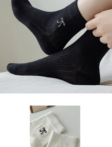 Close-up of ballet style ribbed cotton socks featuring bow embroidery and texture