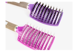 Detail of two purple curved vented hairbrushes with nylon and boar bristles on white background