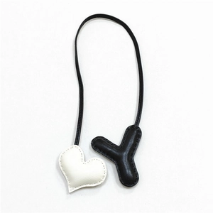 Dettaglio di un ciondolo per borsa in pelle fatto a mano con cuore e lettera Y e cuciture