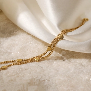 Elegant 18K gold-plated double-layer heart pendant bracelet on white silk texture