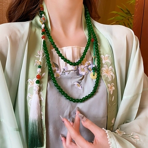 Close-up of a Neo-Chinese tassel necklace with green beads and a decorative pendant