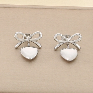 Gros plan sur des boucles d'oreilles cœur avec motif nœud poli sur un support d'exposition