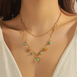 Vintage double layer gold necklace with turquoise star and sun pendants on model