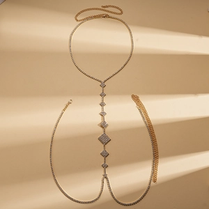 Detail of gold body chain featuring rhinestone-encrusted geometric diamond shapes