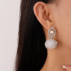 Elegant silver mesh drop earrings with sparkling rhinestones and white pearls on a model