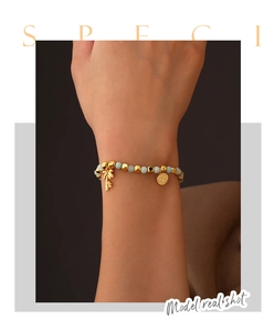 Detail of 14k gold plated beaded bracelet with palm tree charm and stone beads