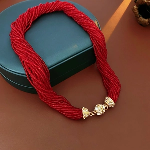 Dettaglio collana multifilo di perline rosse con chiusura magnetica dorata