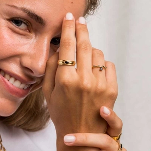 Détail de bagues vintage plaquées or 18k avec pierres noires sur la main d'un mannequin