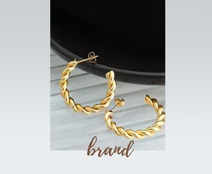 Close-up of twisted rope texture and polished 18K gold finish on C-shaped hoop earrings