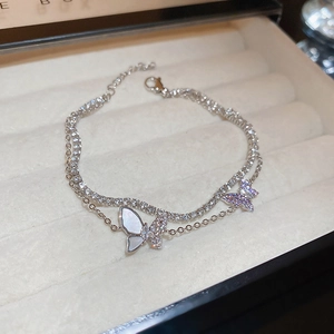 Macro view of double-layered butterfly bracelet with mother of pearl and purple crystals