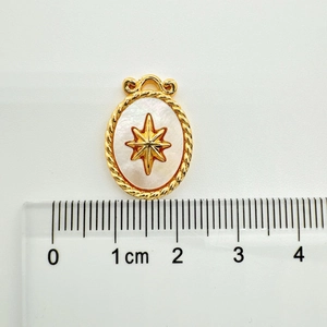 Macro shot of 18k gold-plated oval shell pendant with star detail and 1.8cm scale
