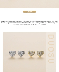 Close-up of heart-shaped stud earrings with pavé diamond setting in gold and silver finish