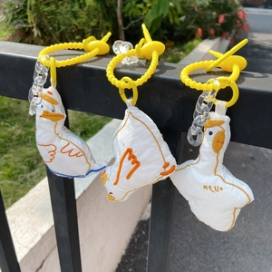 Λεπτομερής λήψη τριών λευκών λούτρινων κρεμαστών πάπιας σε μαύρο μεταλλικό φράχτη