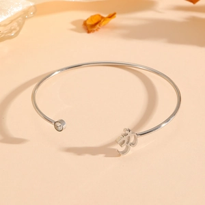 Bracelet jonc ouvert en acier argenté orné d'un zircon brillant et d'un symbole Om