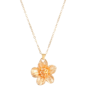 Close-up of golden flower pendant necklace with detailed metal texture on white background