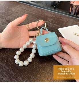 Close-up of light blue faux crocodile leather mini bag keychain with large pearls