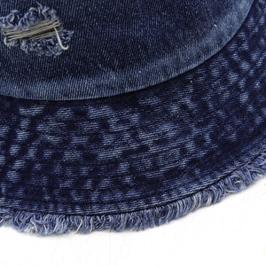 Gros plan d'un chapeau bob en denim avec détails déchirés et bords effilochés rétro