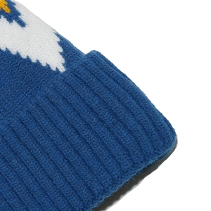 Dettaglio ravvicinato di berretto in maglia blu con motivo jacquard bianco e texture morbida