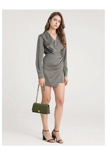 Fashionable model wearing a dark green quilted flap bag with golden chain strap