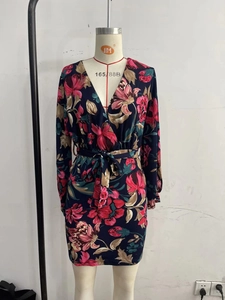 Close-up of deep V-neckline and vibrant floral print on long sleeve wrap dress