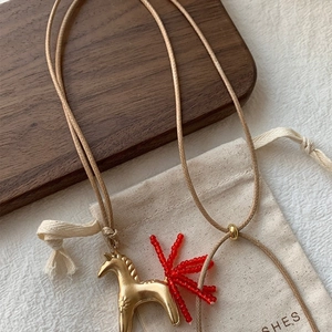 Pony pendant necklace with red beaded tail on a light braided cord for women
