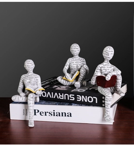 Dettaglio di figurine di lettori nordici in resina con motivi tipografici su libri