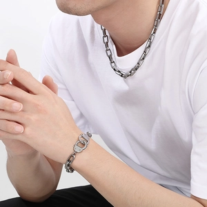 Close-up of industrial silver chain necklace and handcuff bracelet on male model