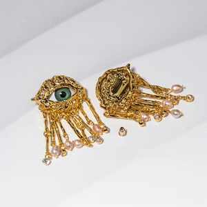 Luxurious gold evil eye earrings featuring green stones, pearls, and tassel chains