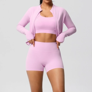Détail d'un ensemble de yoga rose avec veste zippée, brassière et short de sport taille haute