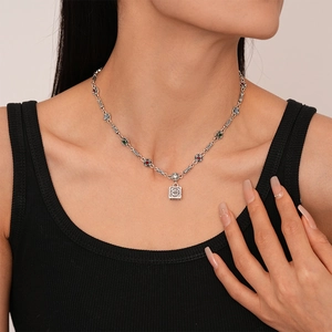 Close-up of retro silver square pendant necklace with colorful gems on a model