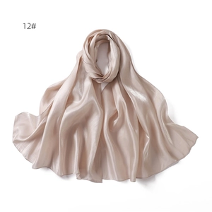 Detail of champagne satin scarf showing smooth silky texture and soft glossy sheen draping