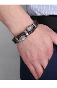 Détail d'un bracelet en cuir tressé marron avec fermoir magnétique en métal argenté ciselé
