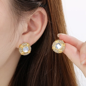 Detail of 18k gold oval earrings with sparkling rhinestones and square crystal center