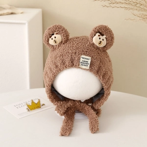 Close-up of brown plush bear ear hat with soft fleece texture and chin straps for warmth