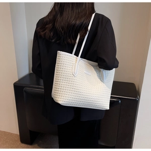 White woven tote bag detail showing large capacity and textured material on shoulder