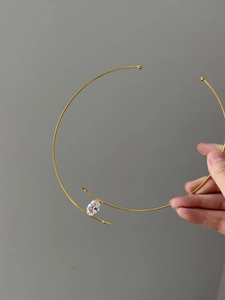 Détail d'un collier ras du cou doré minimaliste orné d'un zircon ovale étincelant