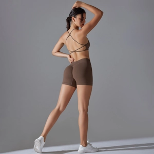 Detail view of seamless cross-back sports bra and high-waist shorts in brown workout set